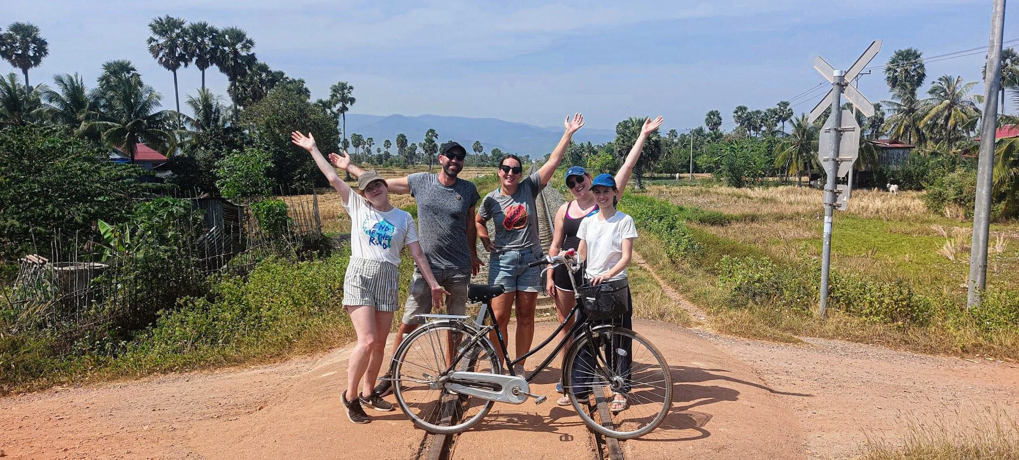 A tour group cheering with their bicycles on a countryside road